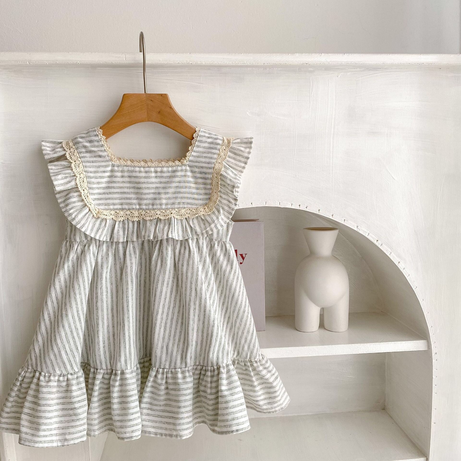 Baby girl wearing a striped sleeveless princess dress in green and light green, showcasing a playful summer style.