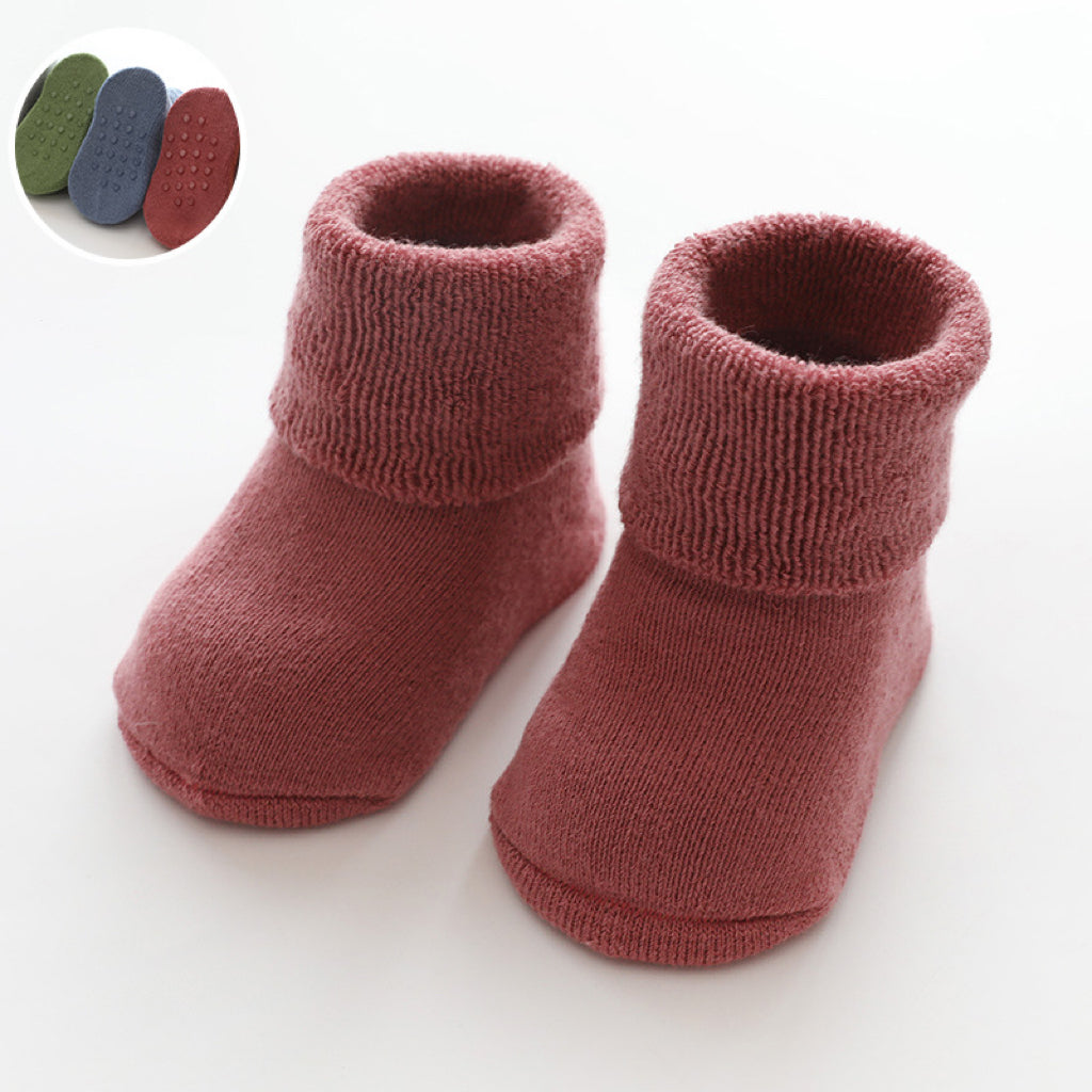 A pair of baby thickened soft cotton anti-slip floor socks in solid color, designed for comfort and safety.