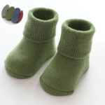 A pair of baby thickened soft cotton anti-slip floor socks in solid color, designed for comfort and safety.