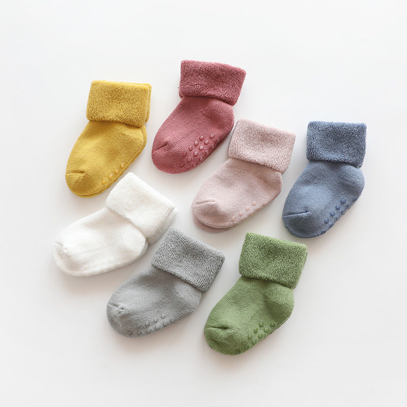 A pair of baby thickened soft cotton anti-slip floor socks in solid color, designed for comfort and safety.