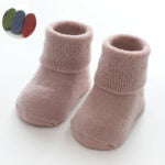 A pair of baby thickened soft cotton anti-slip floor socks in solid color, designed for comfort and safety.