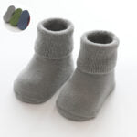 A pair of baby thickened soft cotton anti-slip floor socks in solid color, designed for comfort and safety.