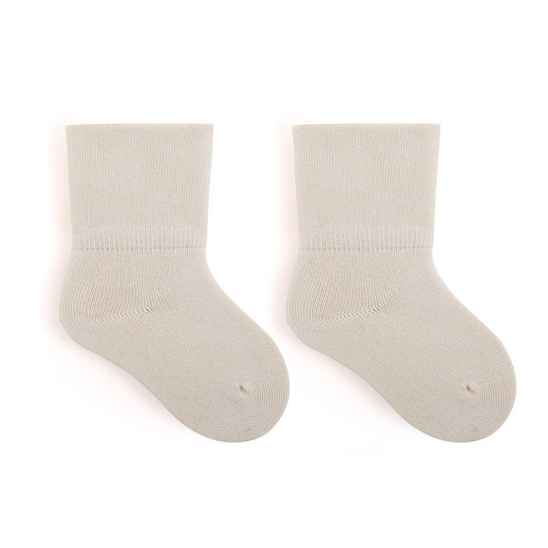 A pair of Baby Unisex Solid Color Breathable Mid-Calf Socks in various colors including white, grey, khaki, beige, and apricot, showcasing their soft fabric and mid-calf length.