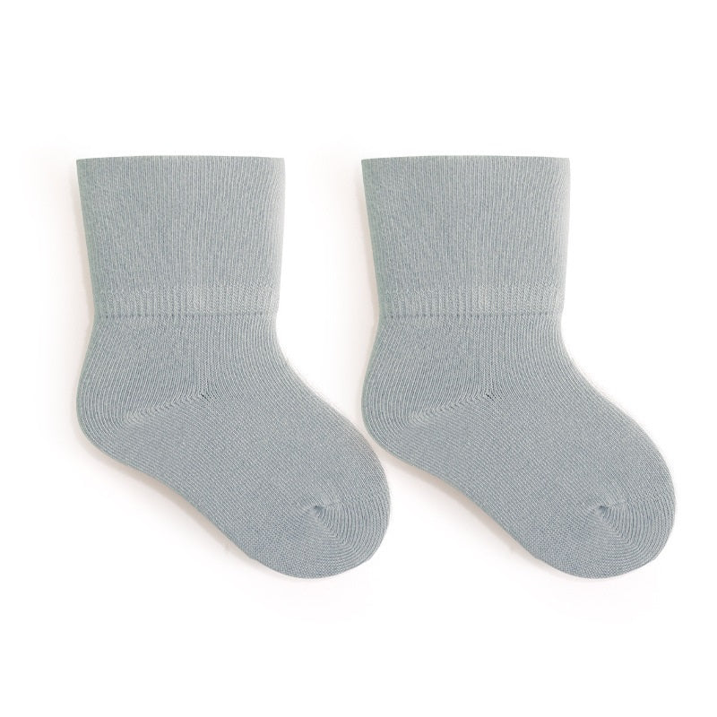 A pair of Baby Unisex Solid Color Breathable Mid-Calf Socks in various colors including white, grey, khaki, beige, and apricot, showcasing their soft fabric and mid-calf length.