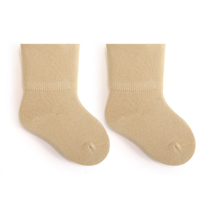 A pair of Baby Unisex Solid Color Breathable Mid-Calf Socks in various colors including white, grey, khaki, beige, and apricot, showcasing their soft fabric and mid-calf length.