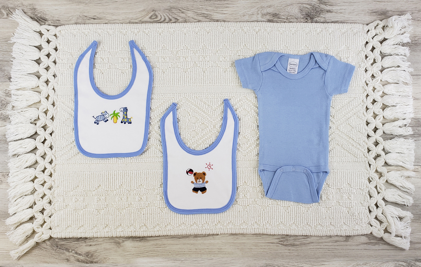 Bambini 3 Pc Layette Baby Clothes Set featuring a blue short sleeve onesie and two white interlock bibs, made from soft cotton for newborn comfort.