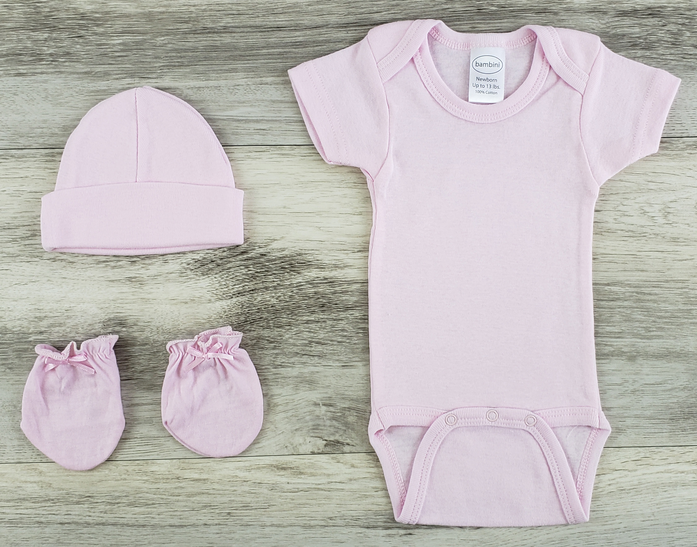 Bambini 3 Pc Layette Baby Clothes Set featuring a pink onesie, cap, and mittens made from soft cotton, perfect for newborns.