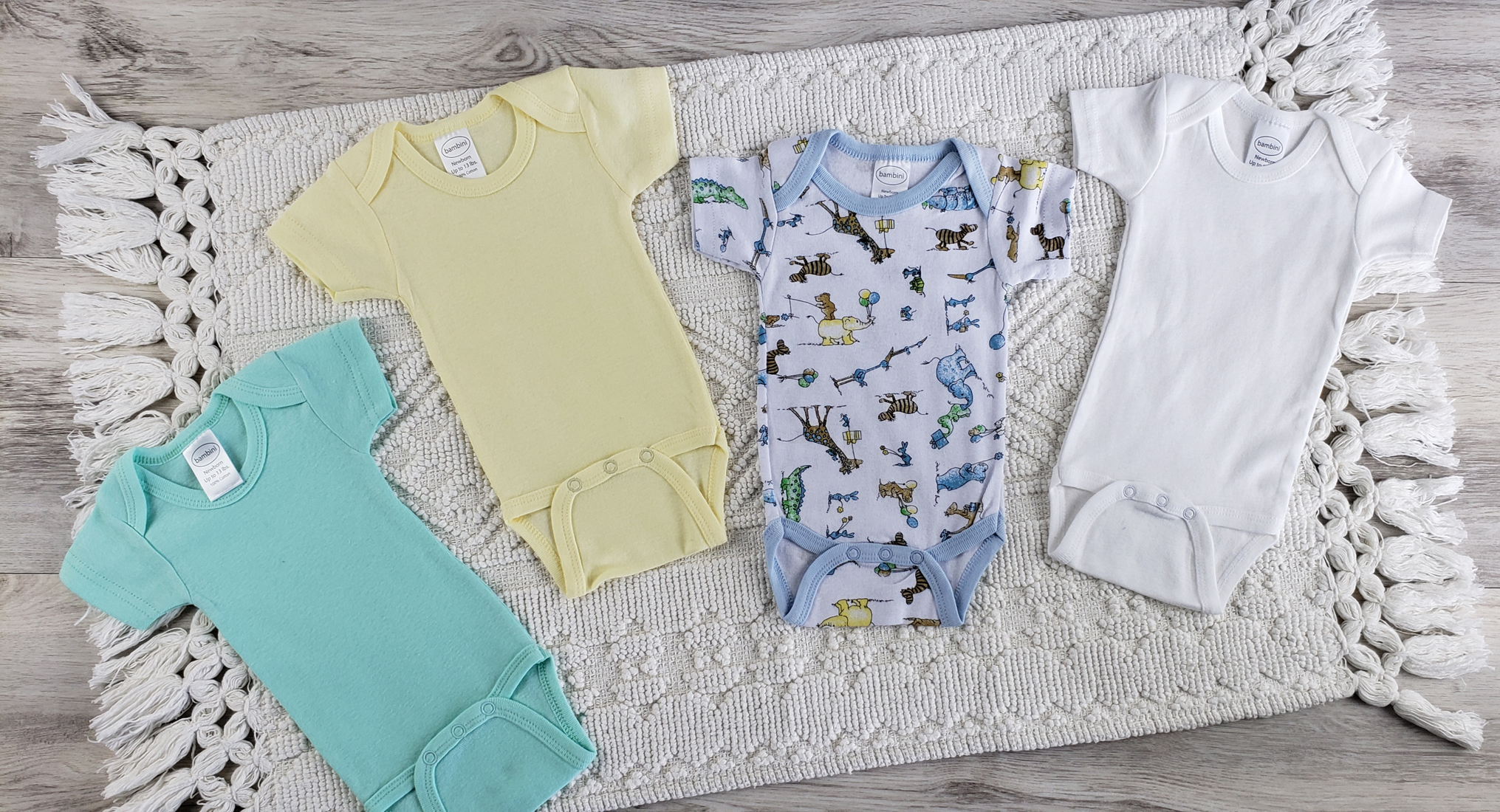 Bambini 4 Pc Layette Baby Clothes Set featuring soft cotton onesies in yellow and printed designs, perfect for newborns.