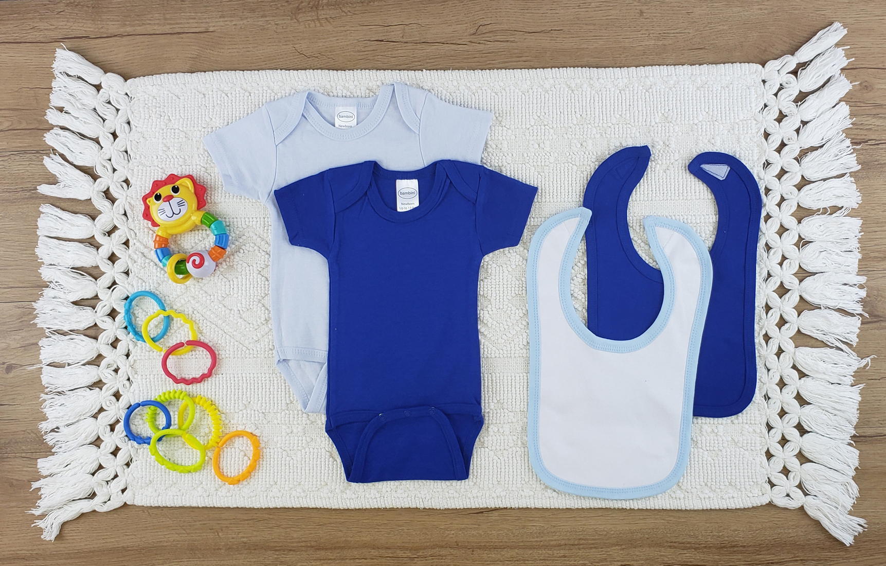 Bambini 4 Pc Layette Baby Clothes Set featuring soft cotton bibs and onesies in white and royal blue, perfect for newborns.