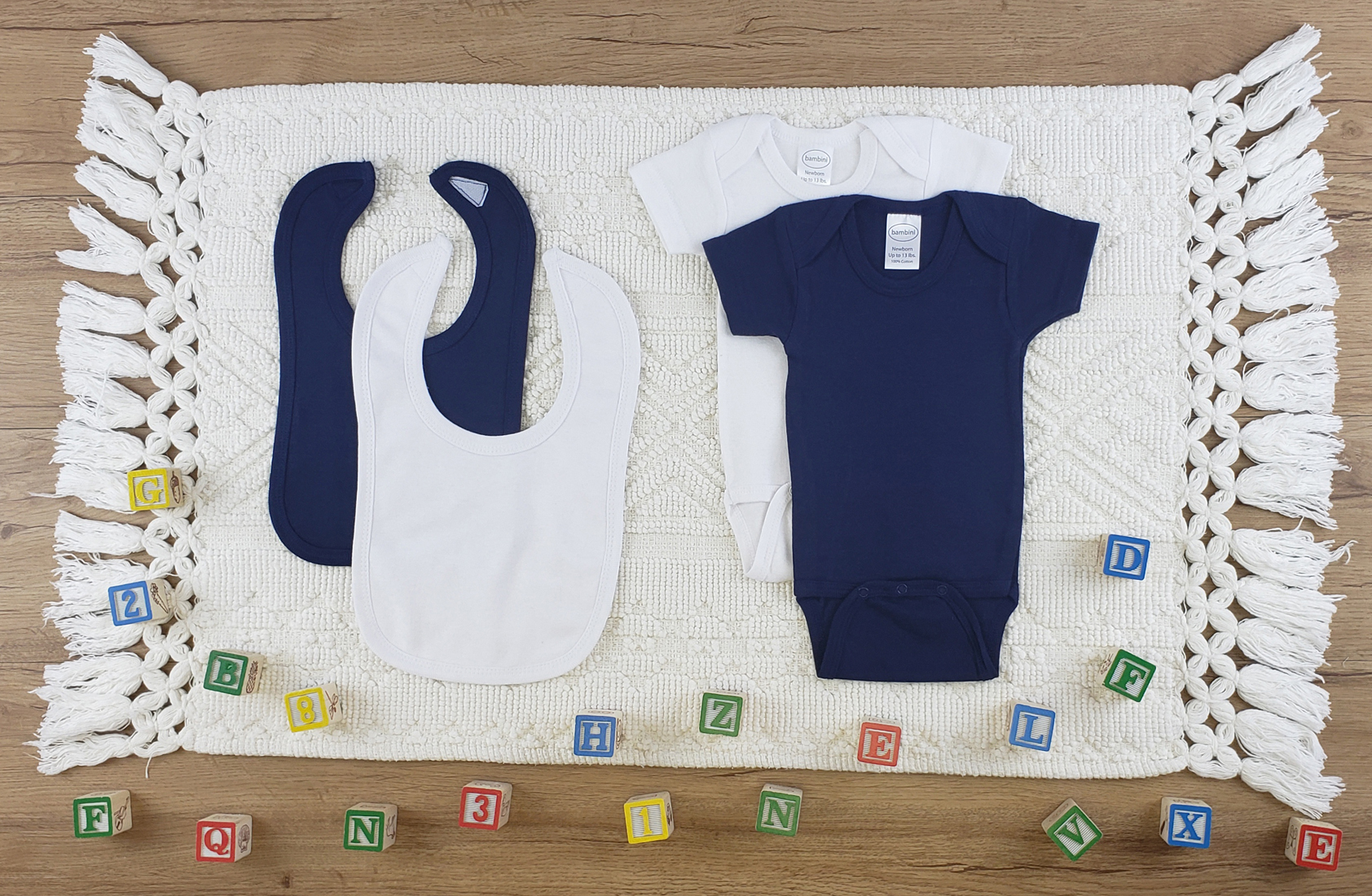 Bambini 4 Pc Layette Baby Clothes Set featuring soft cotton bibs and onesies in navy and white, perfect for newborns.