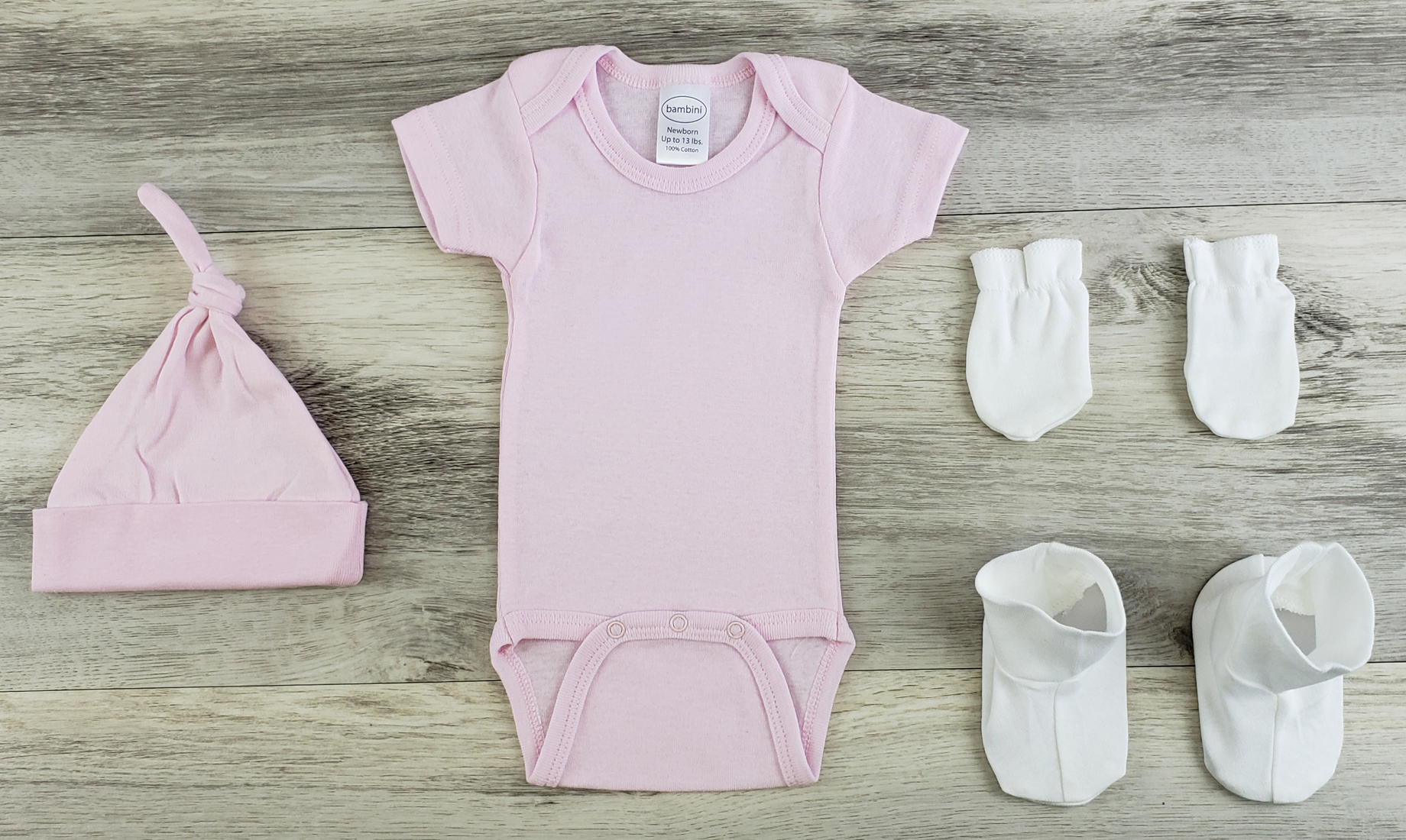 Bambini 5 Pc Layette Baby Clothes Set featuring a pink onesie, knotted cap, mittens, and booties, all made from soft cotton.