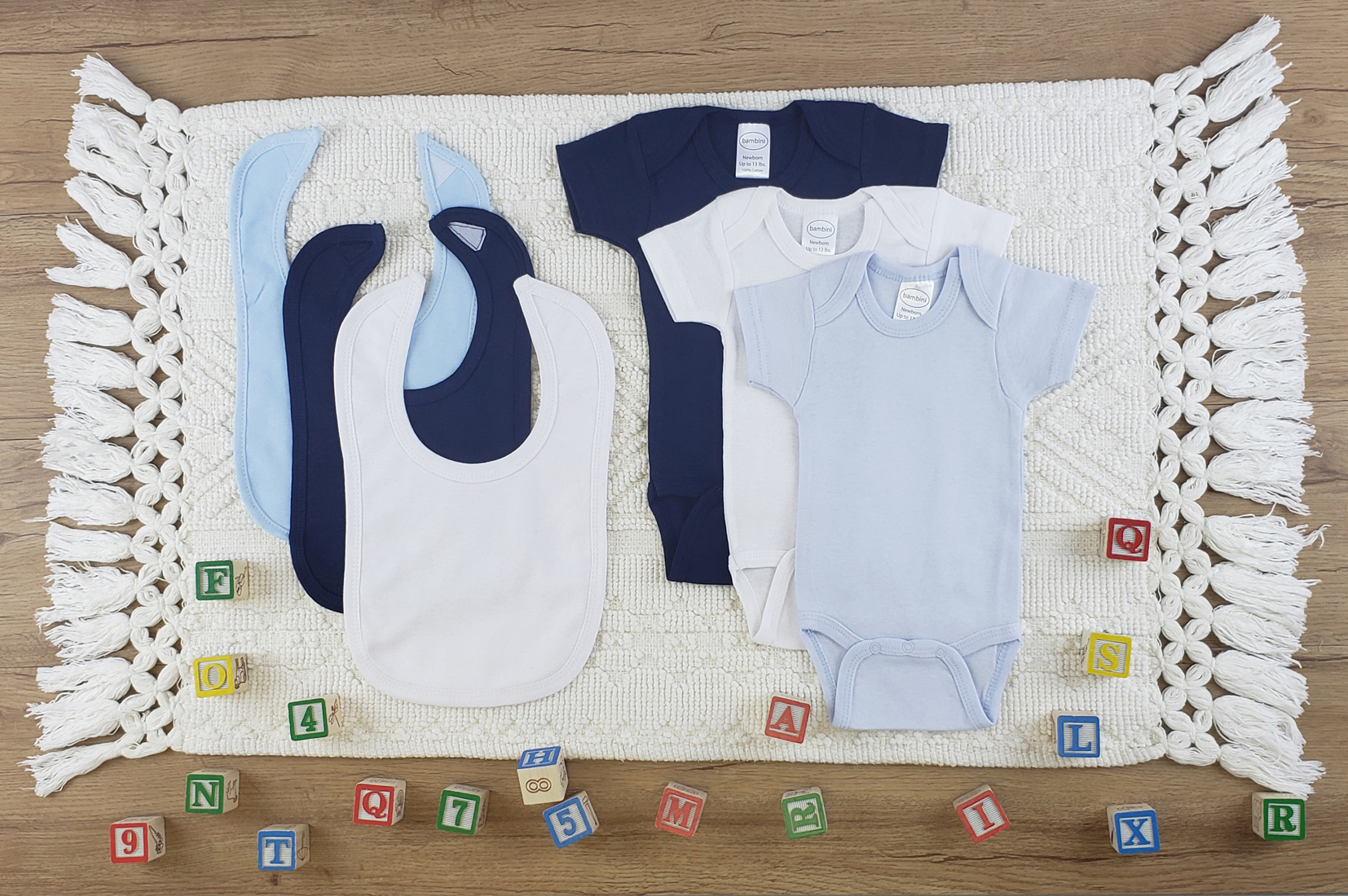 Bambini 6 Pc Layette Baby Clothes Set featuring soft cotton onesies and bibs in various colors, perfect for newborns.