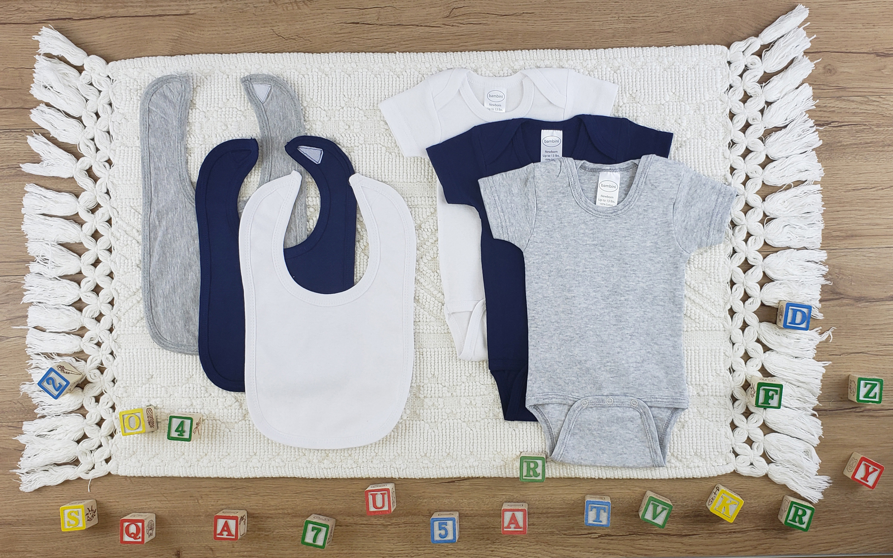 Bambini 6 Pc Layette Baby Clothes Set featuring soft cotton onesies and bibs in various colors, perfect for newborn comfort.