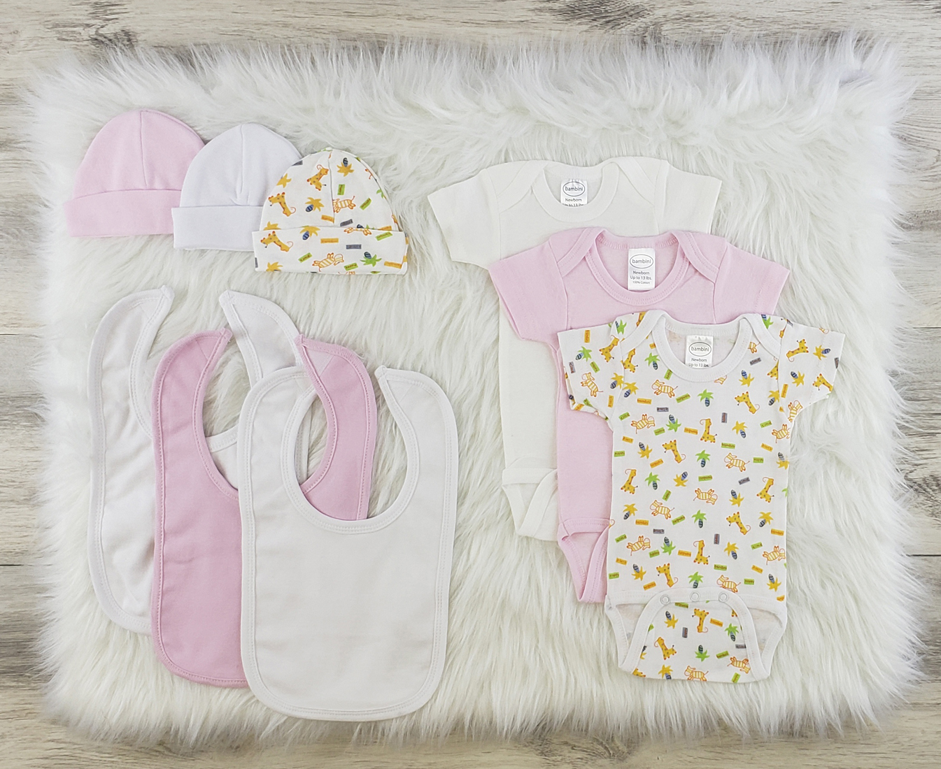 Bambini 9 Pc Layette Baby Clothes Set featuring soft cotton onesies, baby caps, and bibs in pink and white colors.