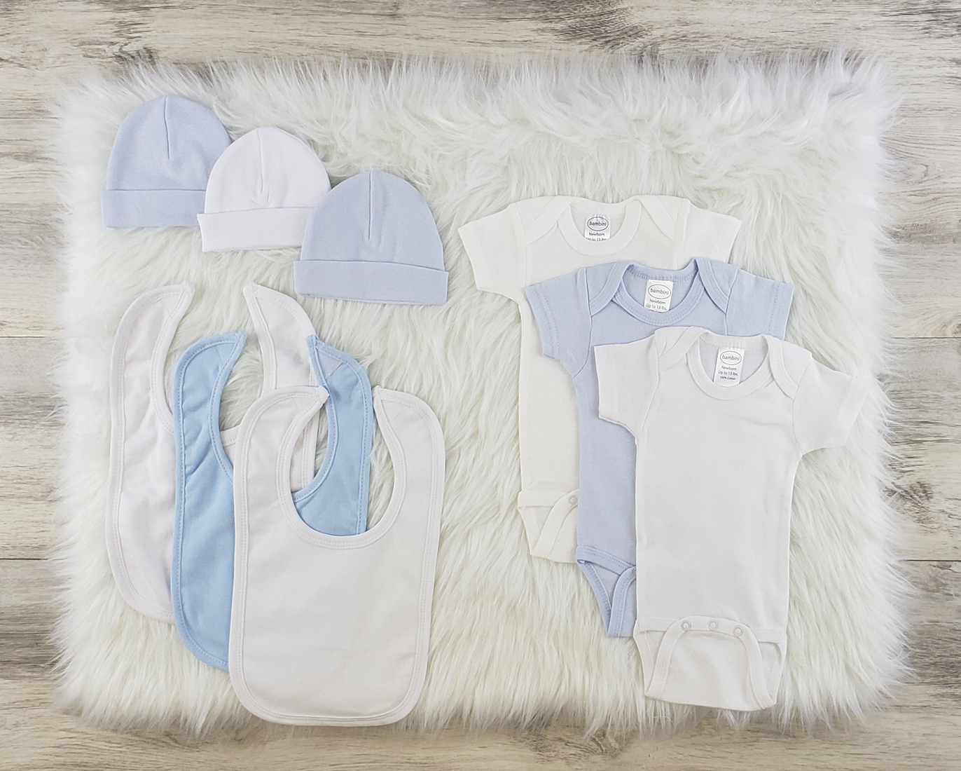 Bambini 9 Pc Layette Baby Clothes Set featuring soft cotton onesies, baby caps, and bibs in blue and white colors, perfect for newborns.