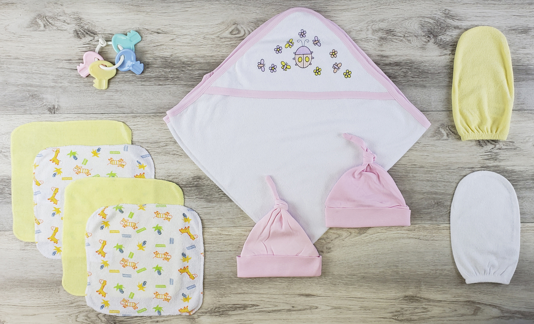 Bambini Hooded Towel set featuring soft cotton towel, pink knotted baby cap, and wash cloths, ideal for newborns.