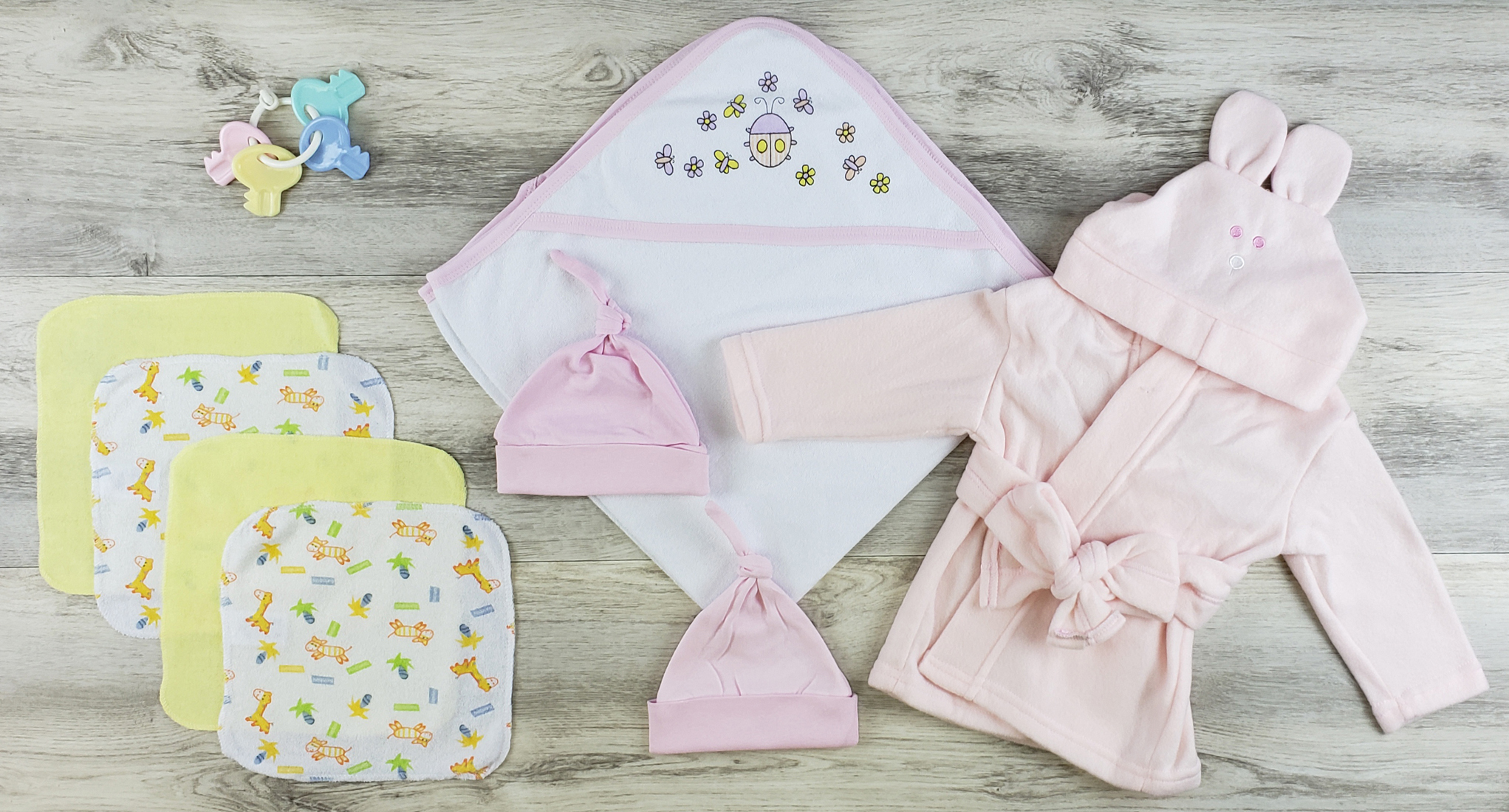 Bambini Hooded Towel and Layette Set featuring soft cotton fabric, pink fleece robe, and wash cloths, perfect for newborns.