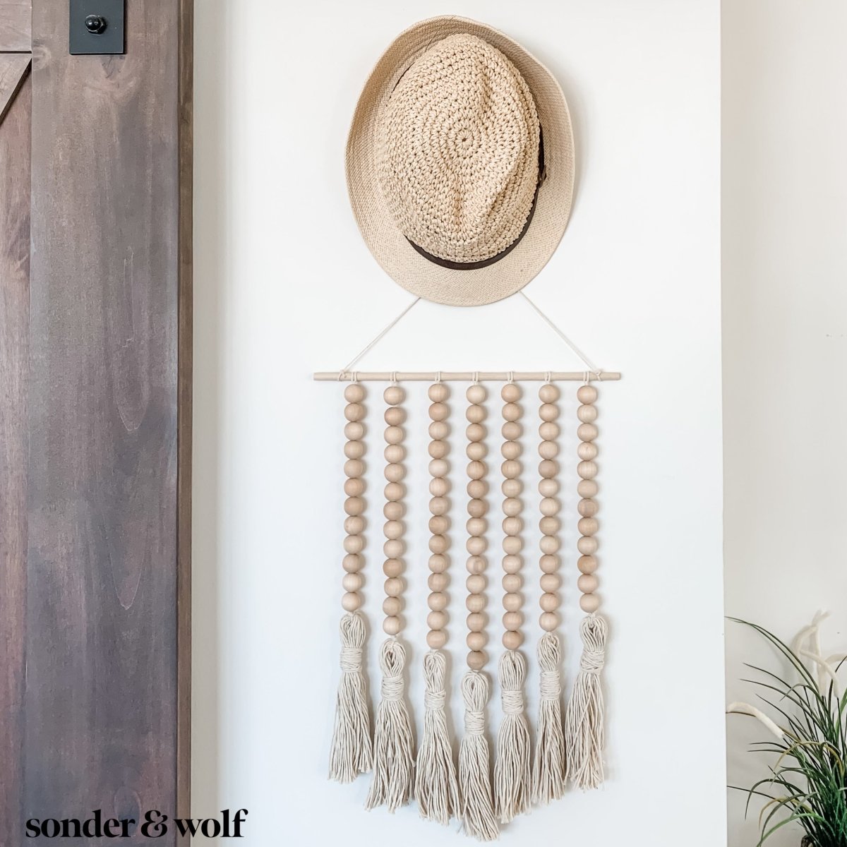 Beaded Wall Art featuring wooden beads and cotton tassels, showcasing a boho-inspired design perfect for home decor.