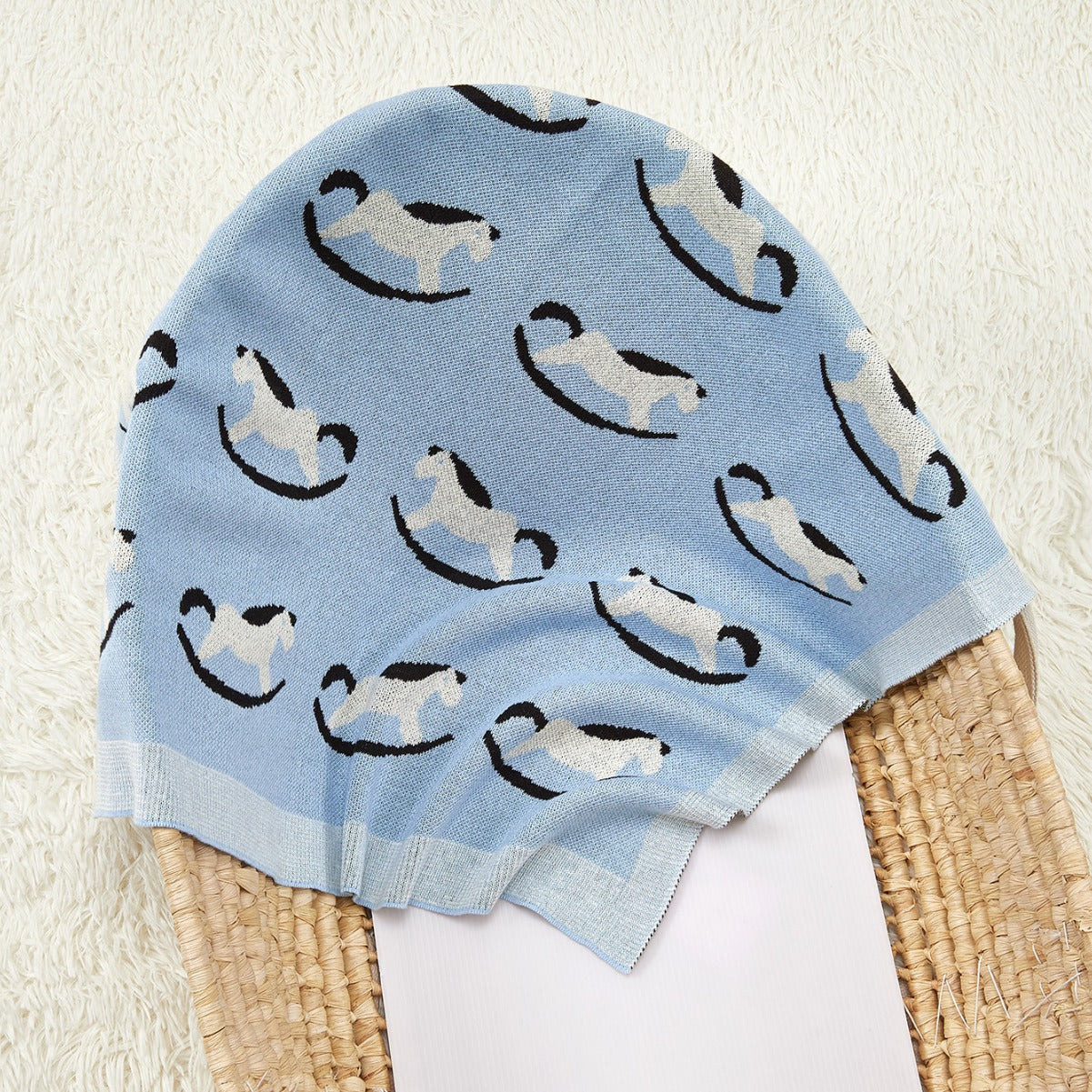 A cozy knitted baby blanket featuring a charming horse pattern in blue and coffee colors, perfect for children of all ages.