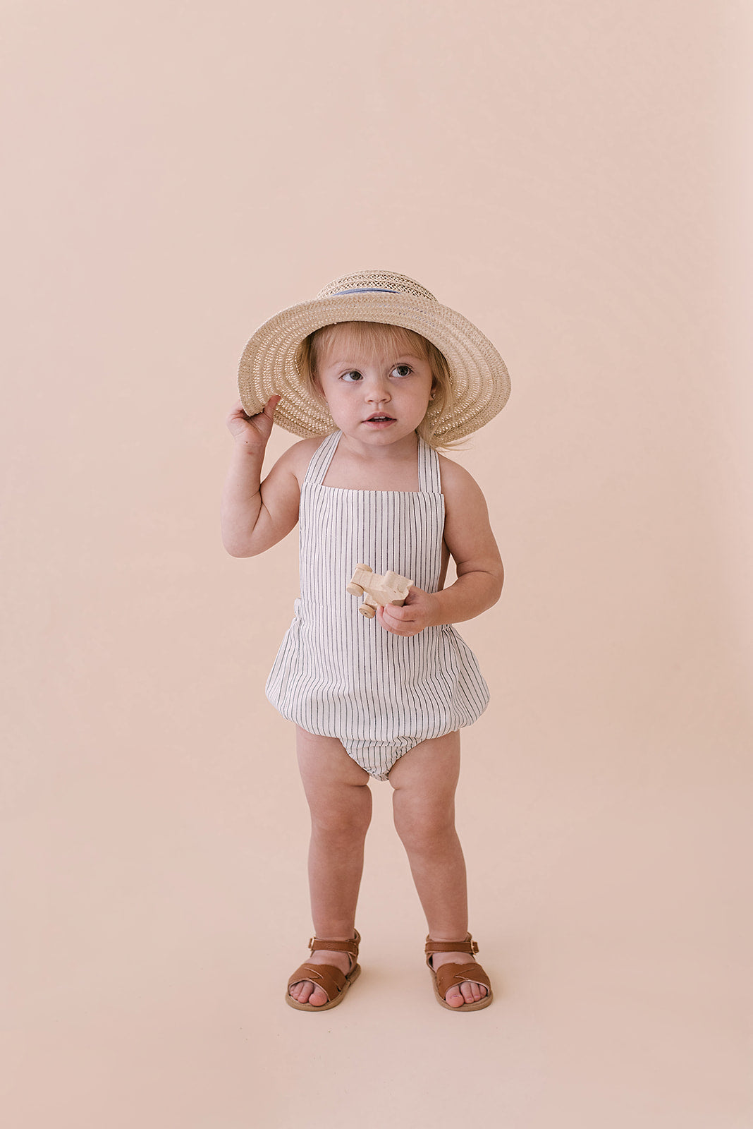 Black & White Striped Halter Romper for babies, featuring a stylish design with easy diaper snaps and made from soft linen fabric.