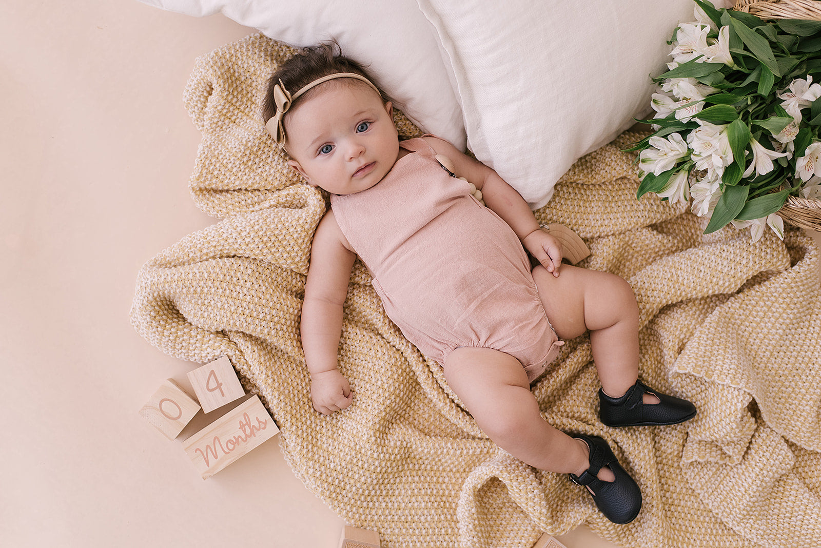 A stylish blush halter romper for babies, made from soft linen with diaper snaps.