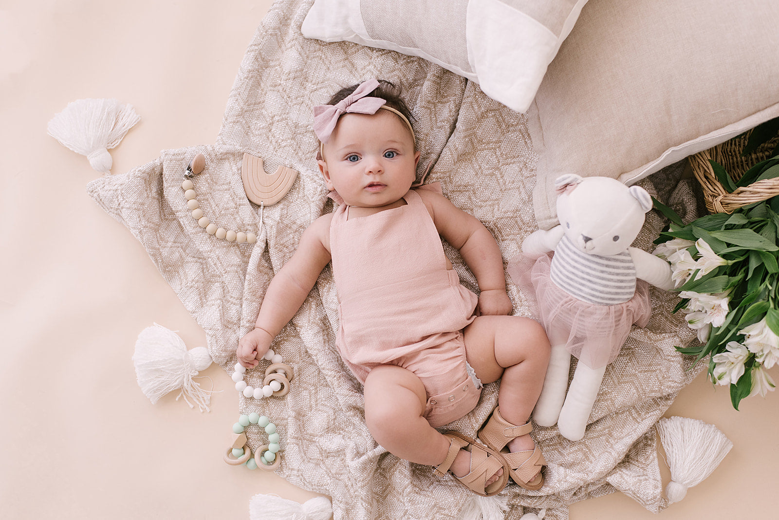 A stylish blush halter romper for babies, made from soft linen with diaper snaps.