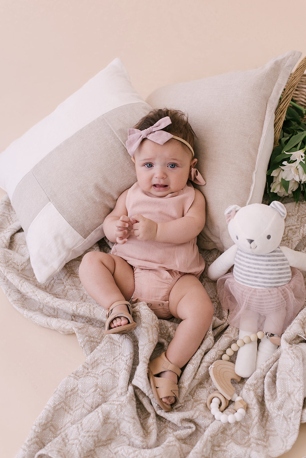 A stylish blush halter romper for babies, made from soft linen with diaper snaps.