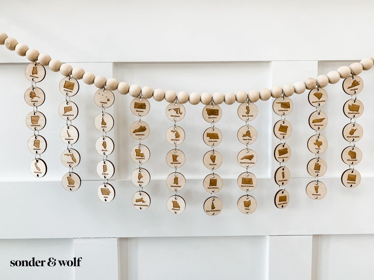 A beautifully crafted 6FT Bucket List States Wood Bead Garland featuring light unfinished wood beads, perfect for home decor.