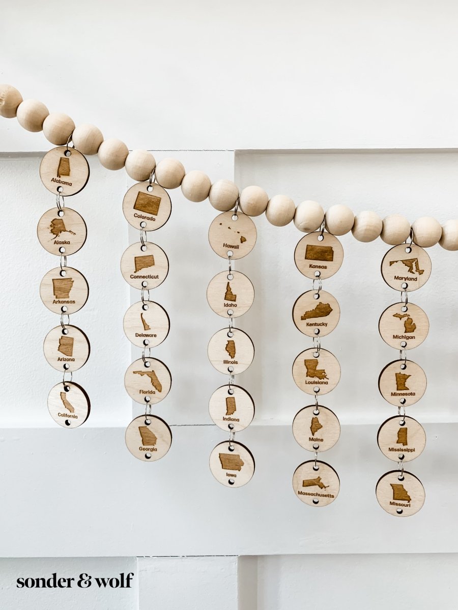 A beautifully crafted 6FT Bucket List States Wood Bead Garland featuring light unfinished wood beads, perfect for home decor.