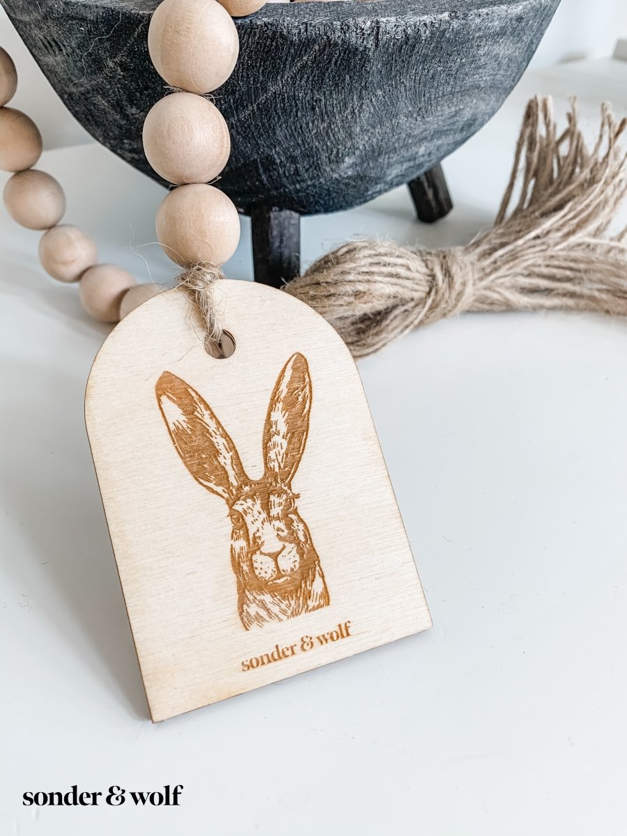 Bunny Wood Bead Garland featuring light wood beads and a jute tassel, perfect for home decor.