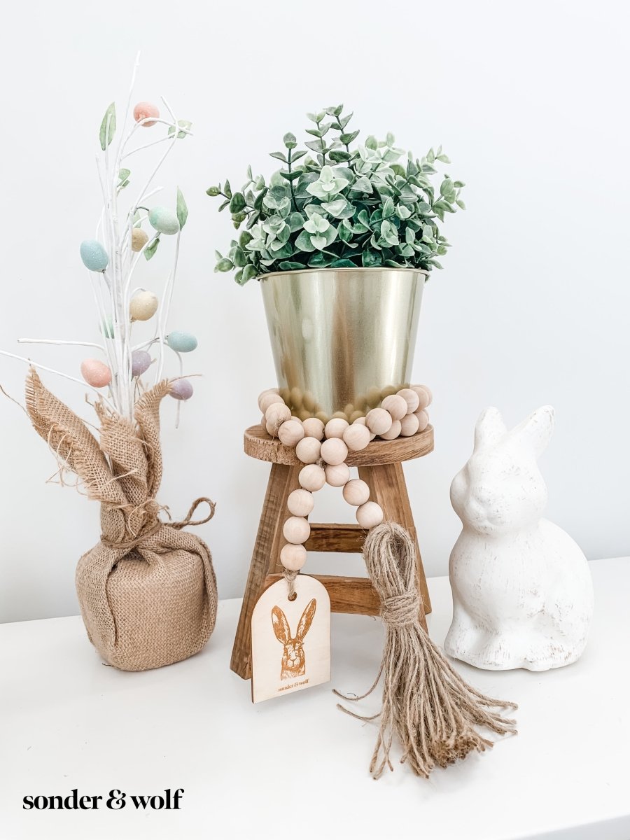 Bunny Wood Bead Garland featuring light wood beads and a jute tassel, perfect for home decor.