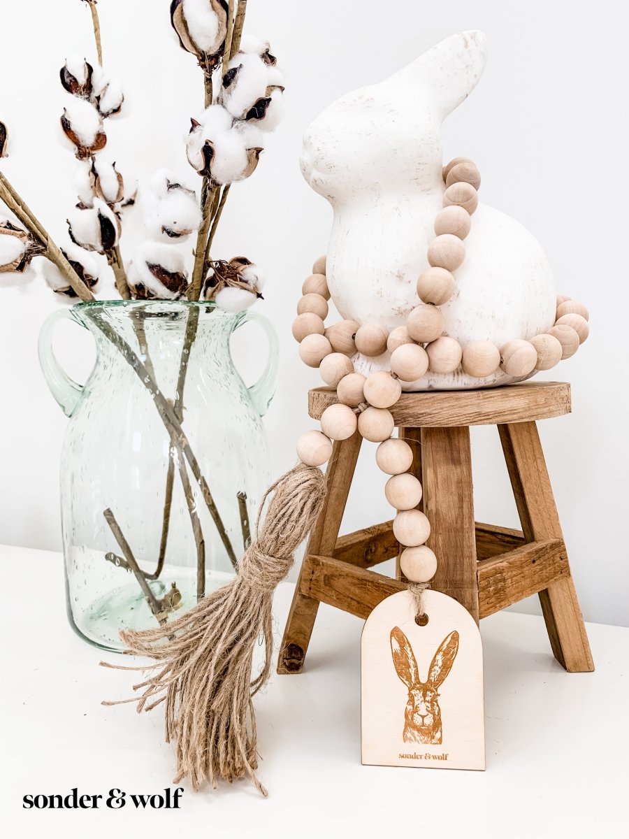 Bunny Wood Bead Garland featuring light wood beads and a jute tassel, perfect for home decor.