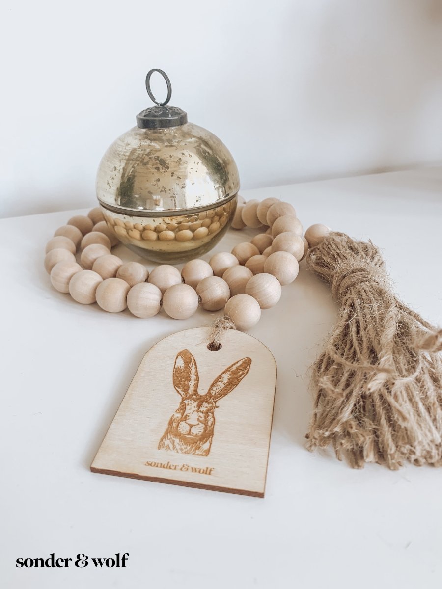 Bunny Wood Bead Garland featuring light wood beads and a jute tassel, perfect for home decor.