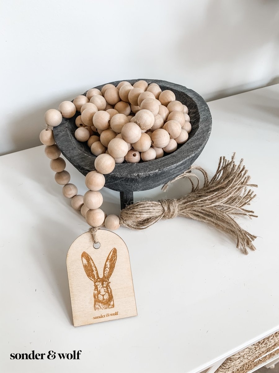 Bunny Wood Bead Garland featuring light wood beads and a jute tassel, perfect for home decor.