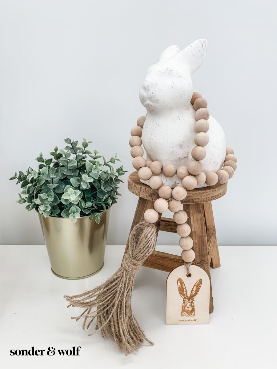 Bunny Wood Bead Garland featuring light wood beads and a jute tassel, perfect for home decor.