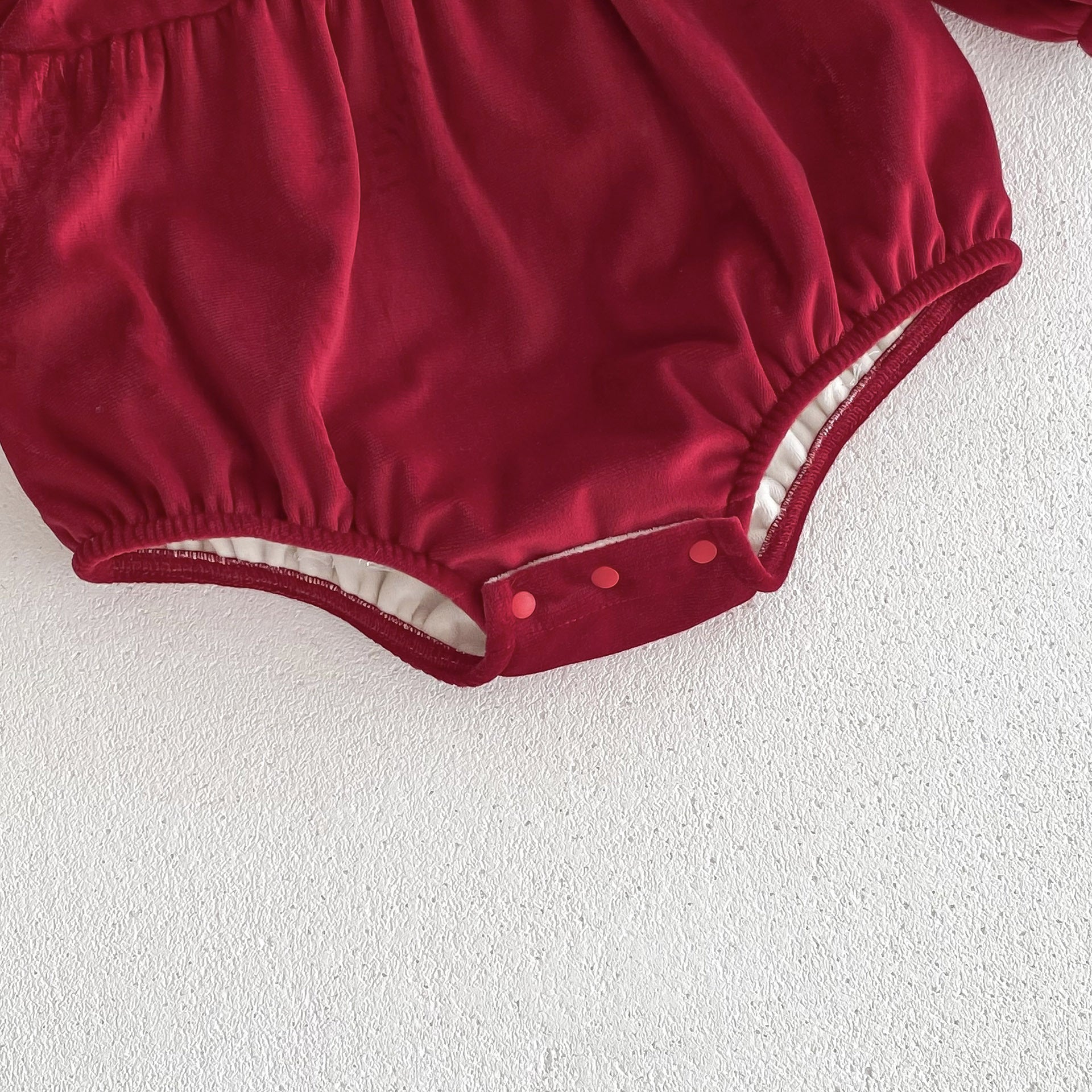 A vibrant red Christmas one-piece for baby girls featuring a laces round collar, perfect for festive occasions.