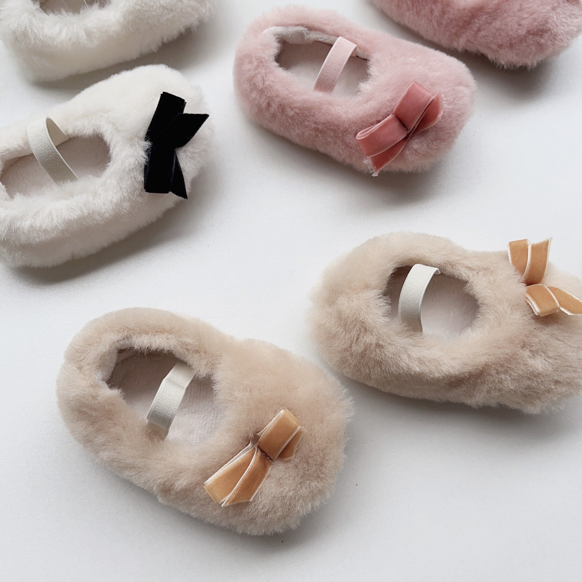 Cute Baby Girl Solid Color Combo Bow Tie Design Plush Warm Anti-Slip shoes in white, pink, and apricot colors, showcasing their soft material and anti-slip sole.