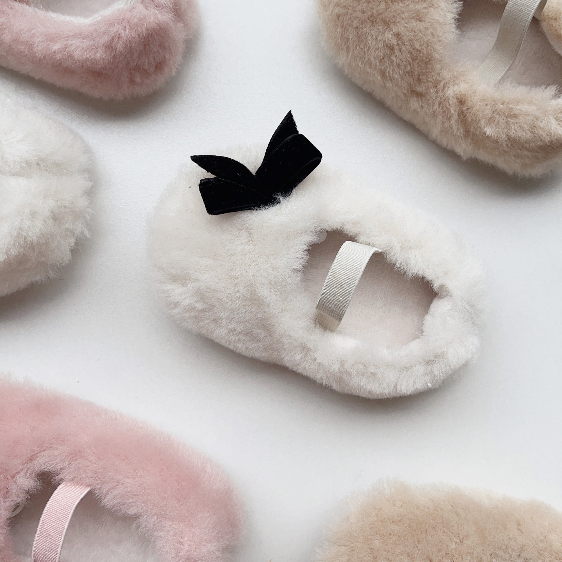 Cute Baby Girl Solid Color Combo Bow Tie Design Plush Warm Anti-Slip shoes in white, pink, and apricot colors, showcasing their soft material and anti-slip sole.