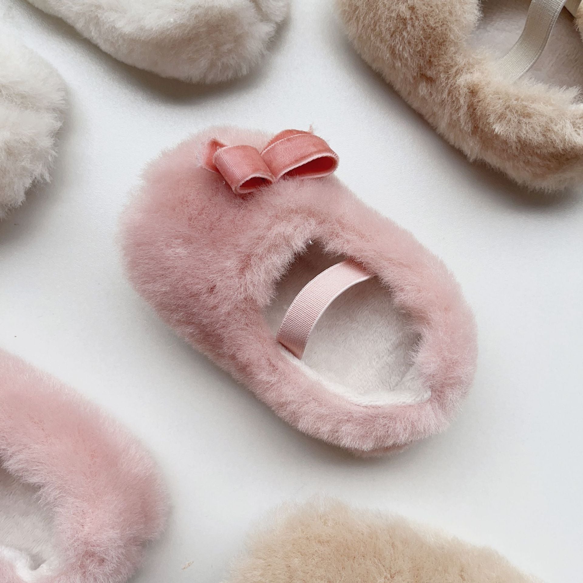 Cute Baby Girl Solid Color Combo Bow Tie Design Plush Warm Anti-Slip shoes in white, pink, and apricot colors, showcasing their soft material and anti-slip sole.