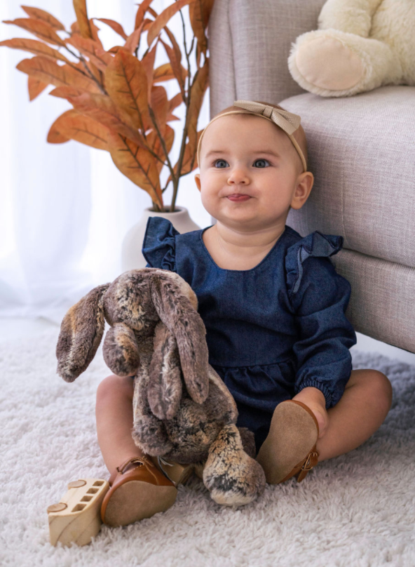 A stylish Denim Flutter Sleeve Romper for babies, featuring soft denim fabric and flutter sleeves, perfect for special occasions.