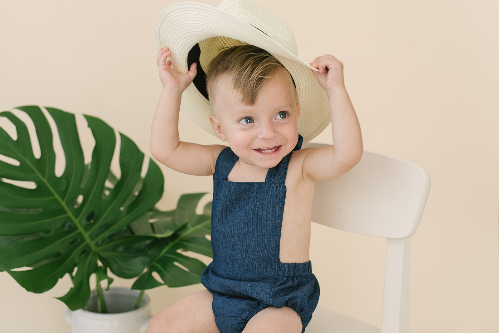 A stylish denim halter romper for babies, featuring easy diaper snaps and a trendy design, perfect for any occasion.