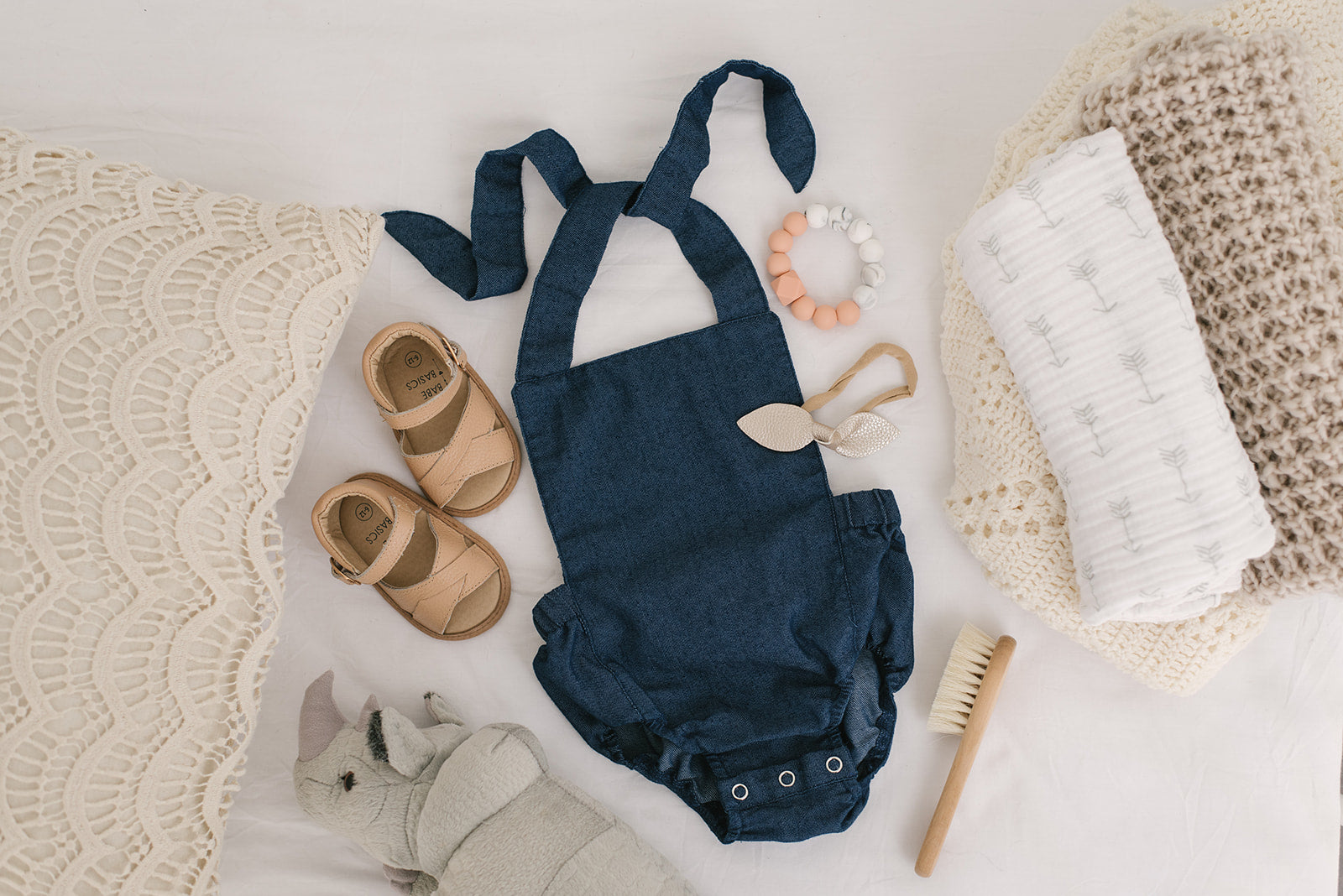 A stylish denim halter romper for babies, featuring easy diaper snaps and a trendy design, perfect for any occasion.