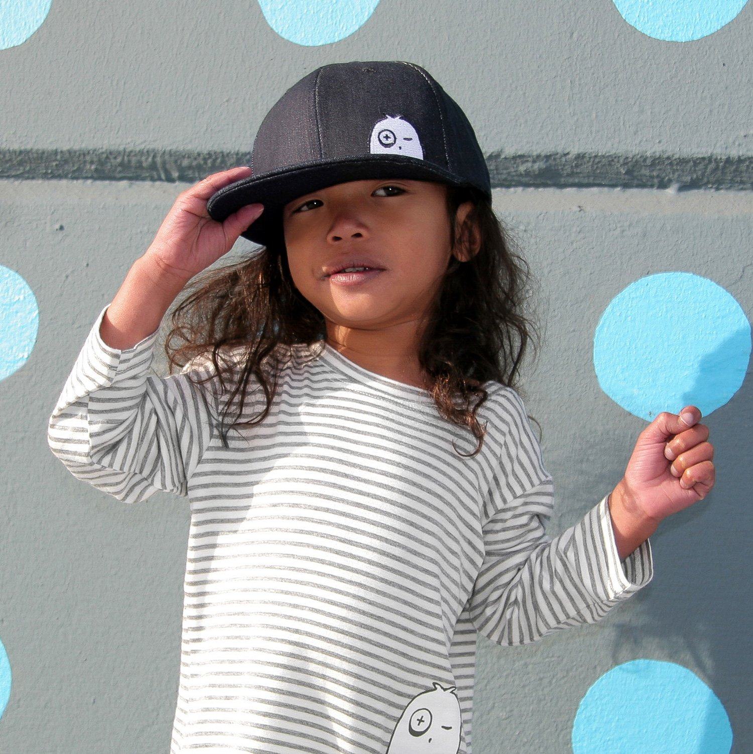 A stylish denim snapback cap for kids, featuring an adjustable snapback fastening and soft cotton material, suitable for ages 1-5.