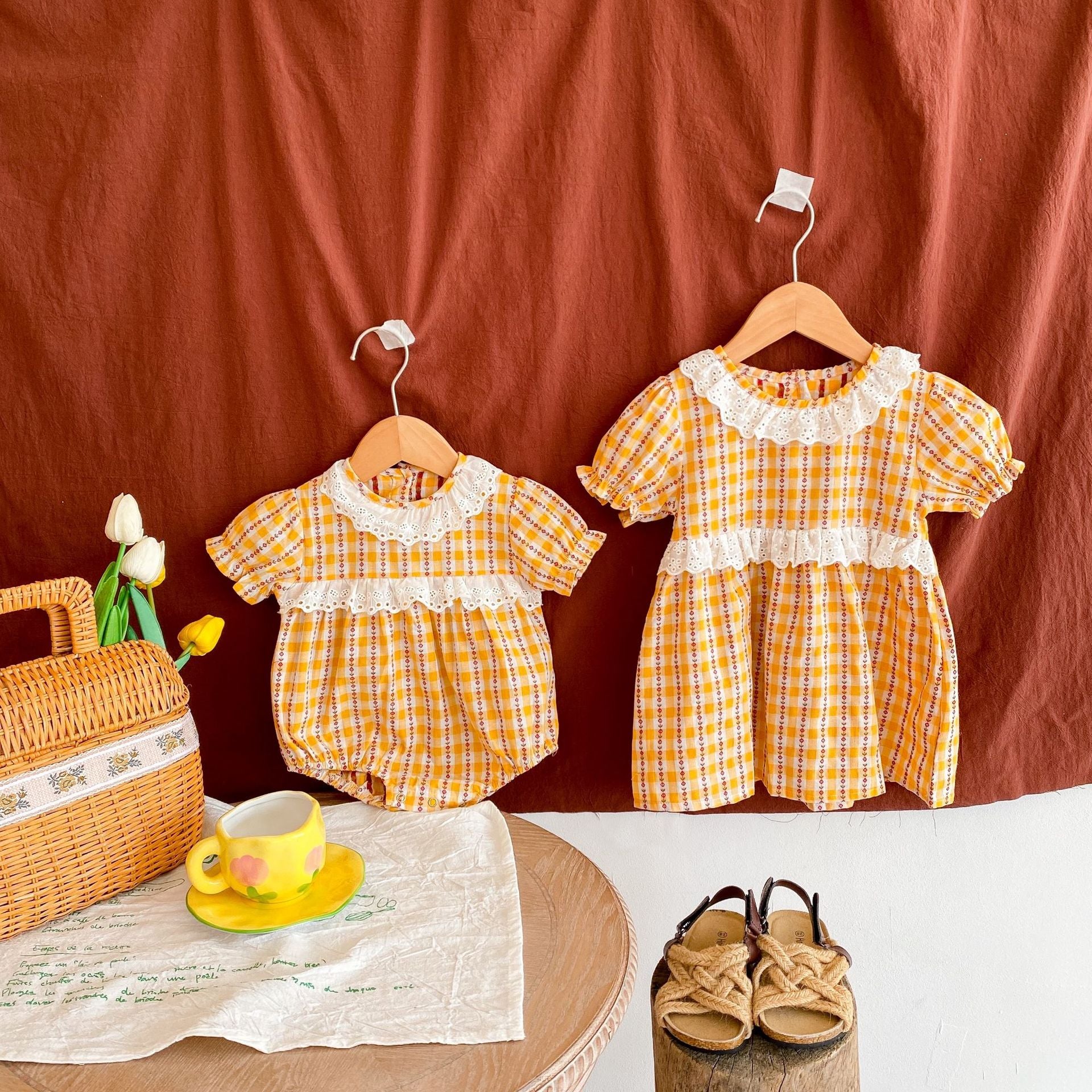 A vibrant yellow summer dress for girls featuring a hollow-out collar and floral striped patterns, perfect for warm weather.