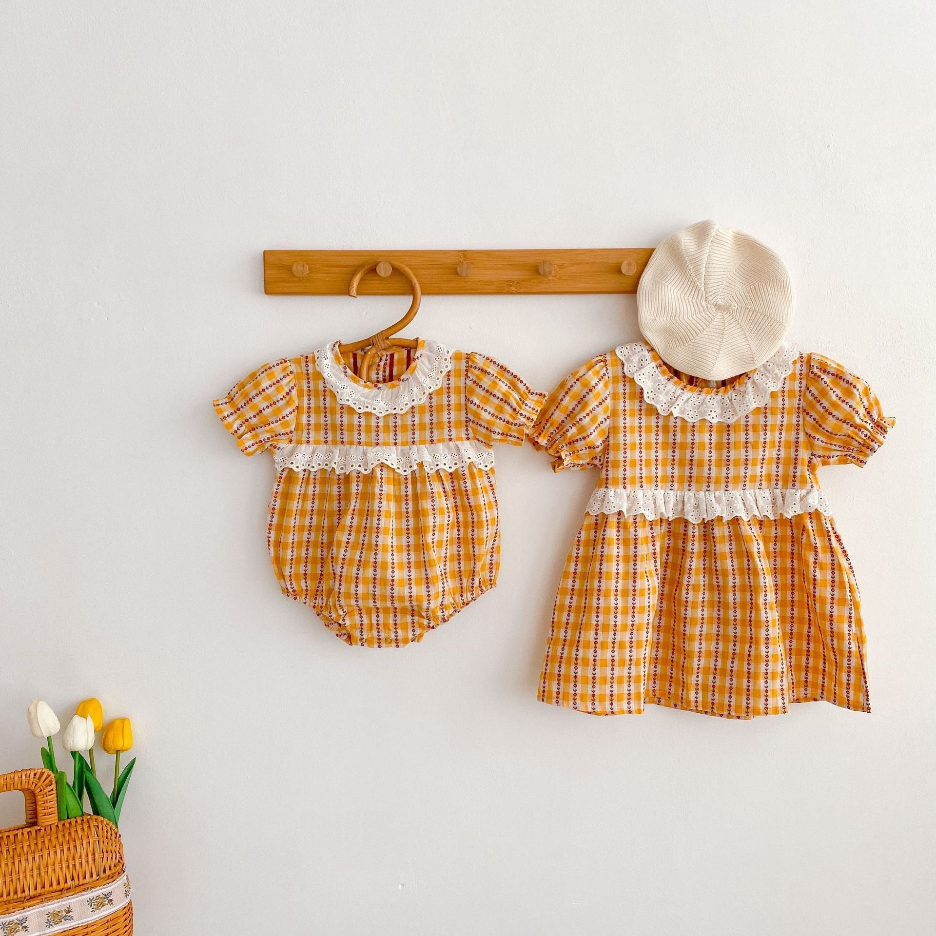 A vibrant yellow summer dress for girls featuring a hollow-out collar and floral striped patterns, perfect for warm weather.