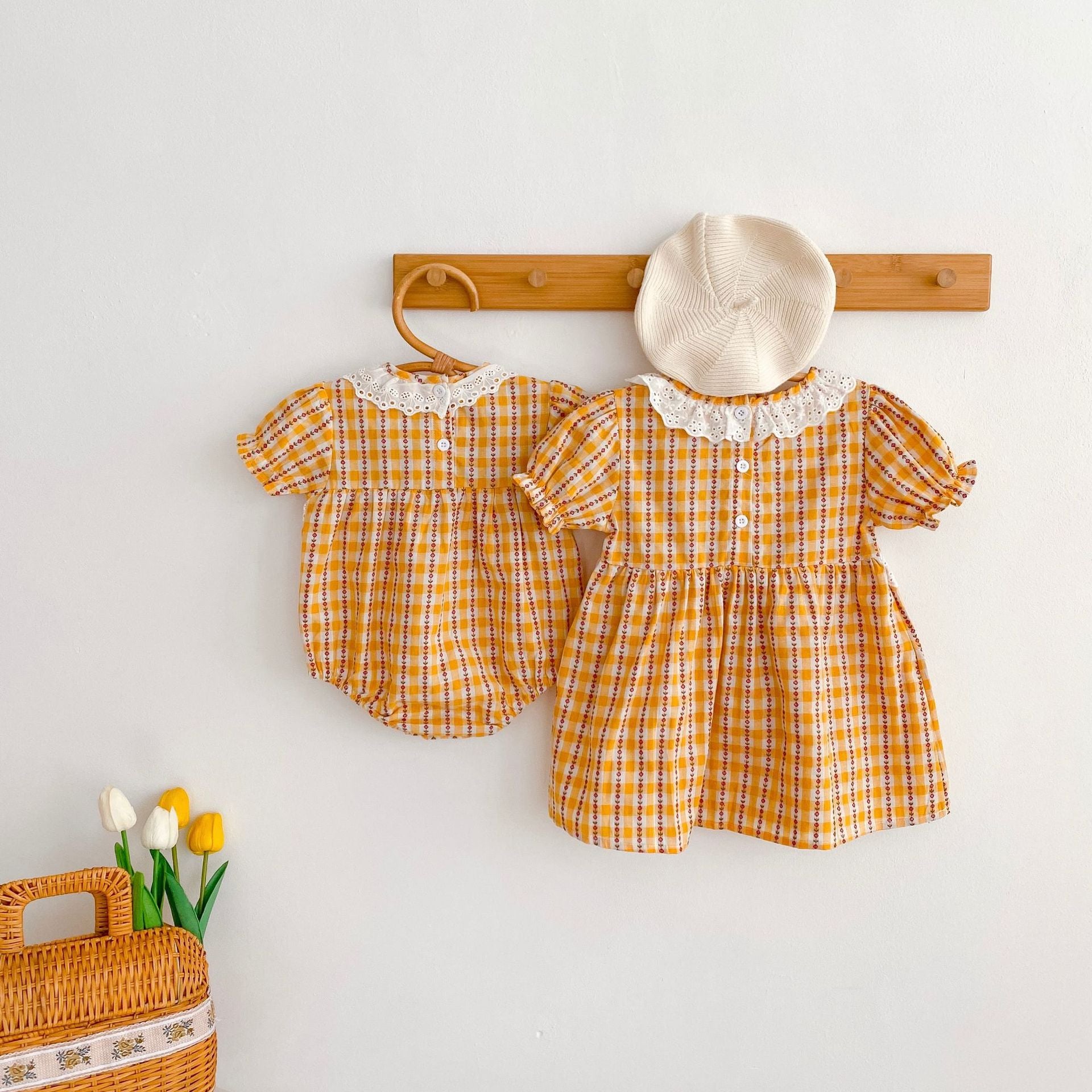 A vibrant yellow summer dress for girls featuring a hollow-out collar and floral striped patterns, perfect for warm weather.