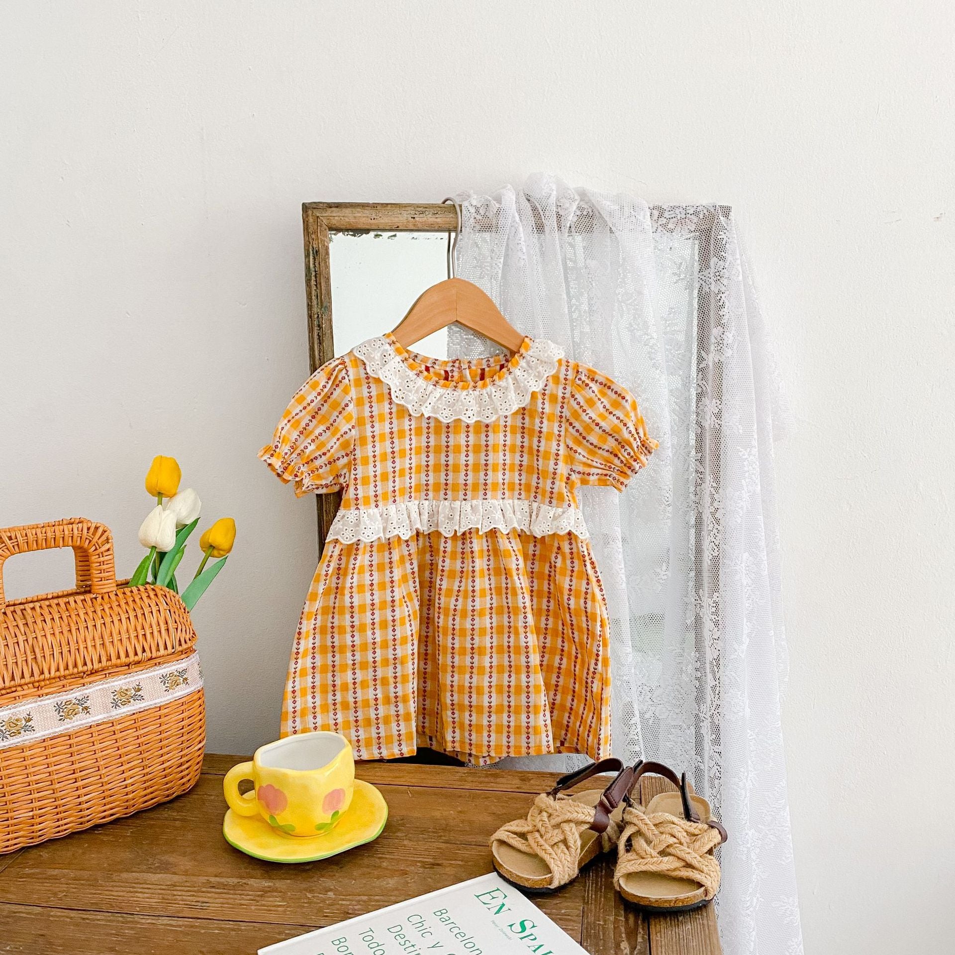 A vibrant yellow summer dress for girls featuring a hollow-out collar and floral striped patterns, perfect for warm weather.