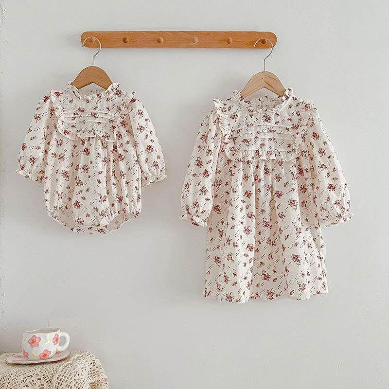 A collection of Ditsy Flower Graphic Sisterly Clothes, featuring floral onesies and dresses in white and red colors, made from soft cotton.