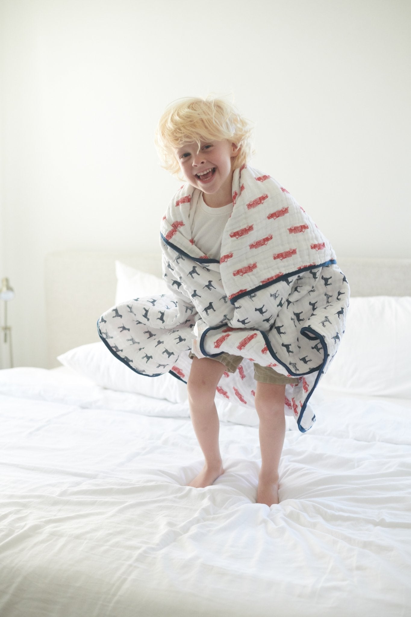 Cozy cotton muslin blanket featuring fire truck and Dalmatian designs, perfect for kids.