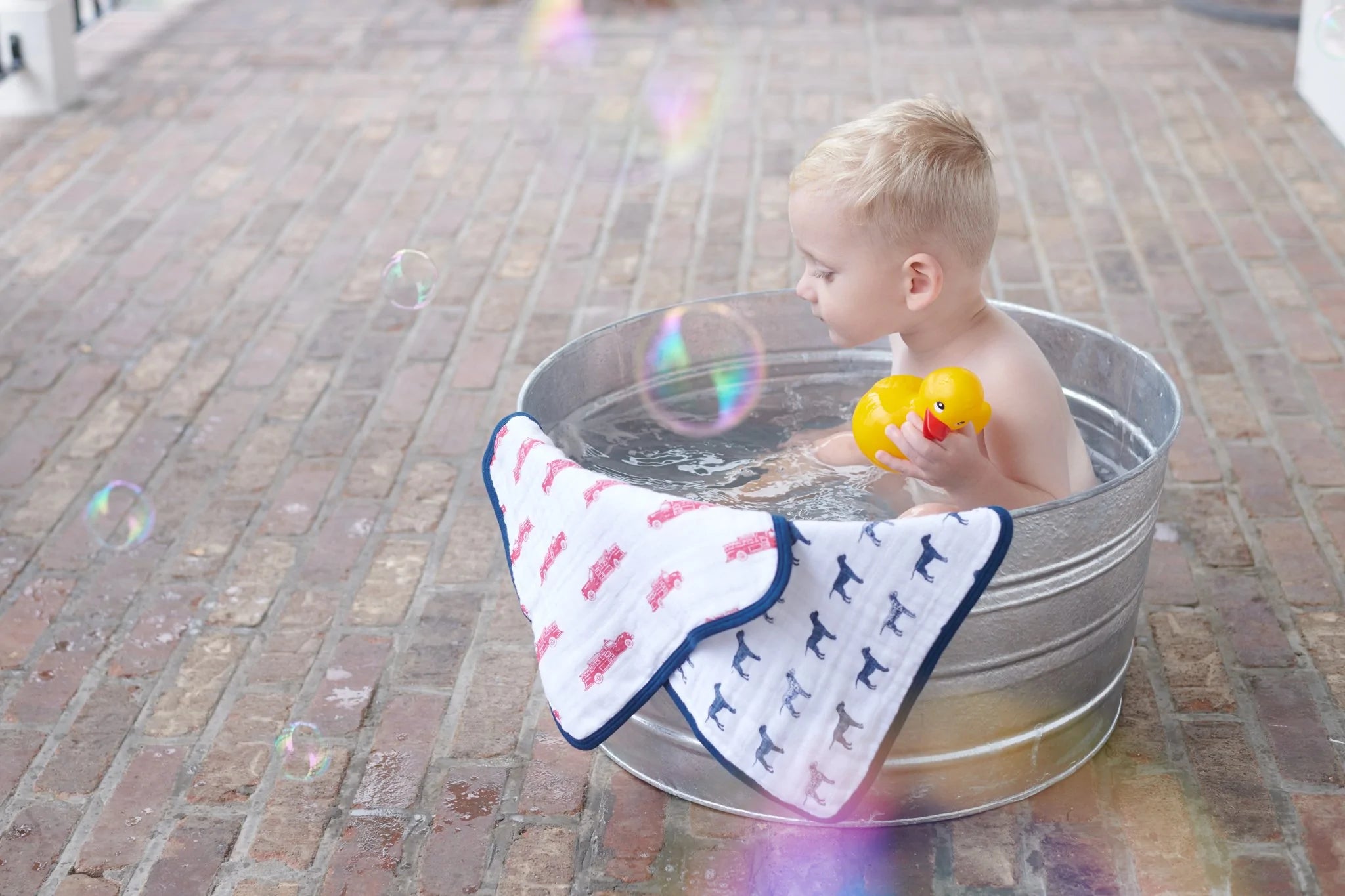 A colorful set of three plush cotton washcloths featuring vibrant fire truck designs, perfect for children's bath time.